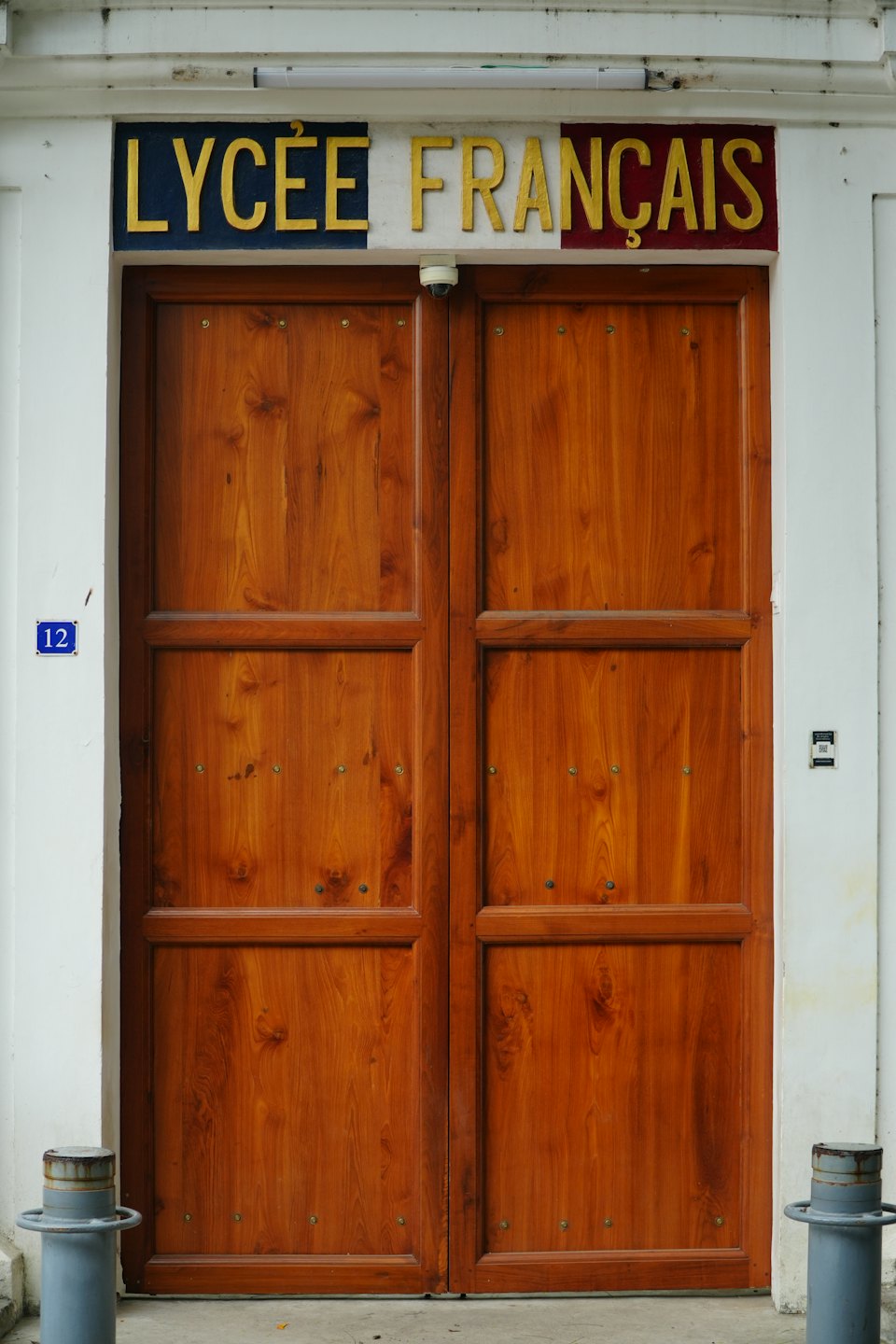 Varnished wooden doors at the entrance of a French school.